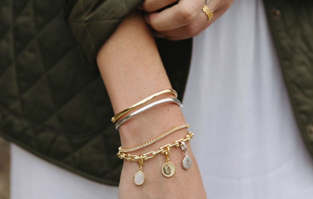 Gold bangle bracelet by Mogano crafted in 14k gold filled or sterling silver with a hinge-style clicker closure. Hypoallergenic, tarnish-resistant jewelry for all skin types.