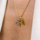 Gold necklace with charms on a person's neck against a white background