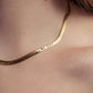 Gold necklace with engraved text on a person's neck