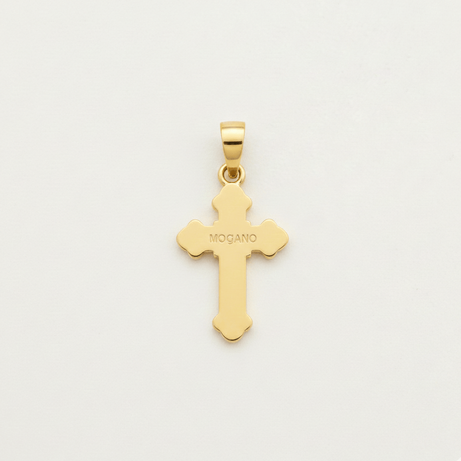 Gold cross pendant with 'MOGANO' engraving on a light gray background