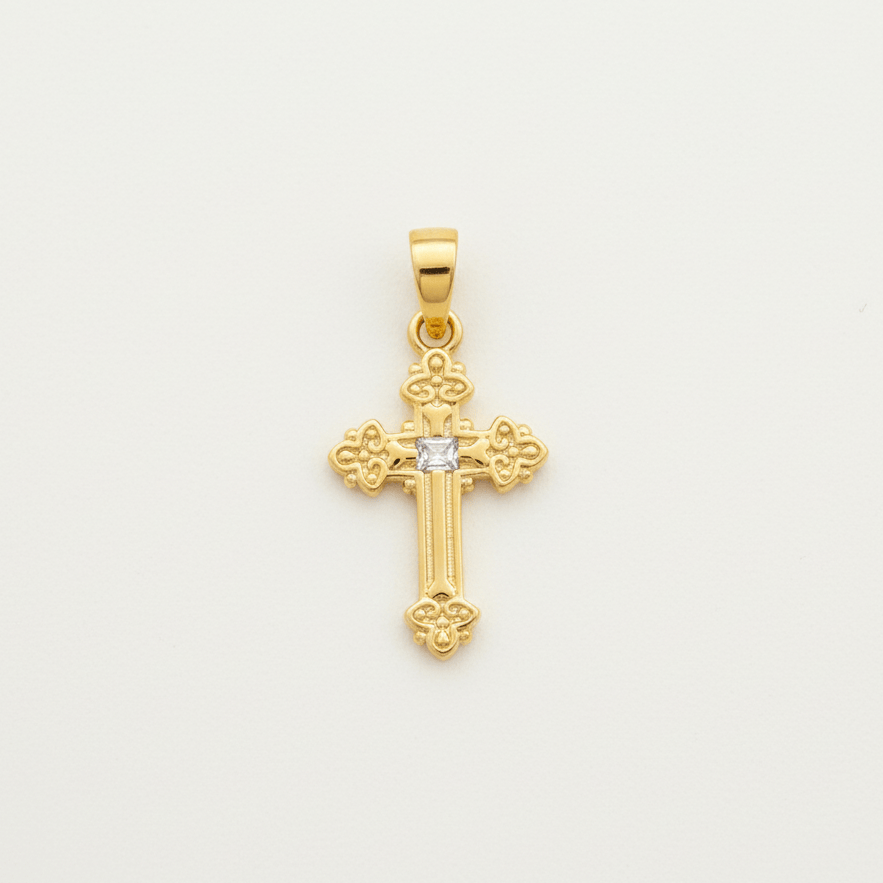Gold cross pendant with a diamond on a light gray background