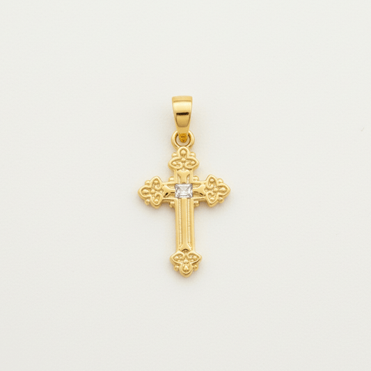 Gold cross pendant with a diamond on a light gray background