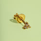Gold earring with small diamonds on a light green background
