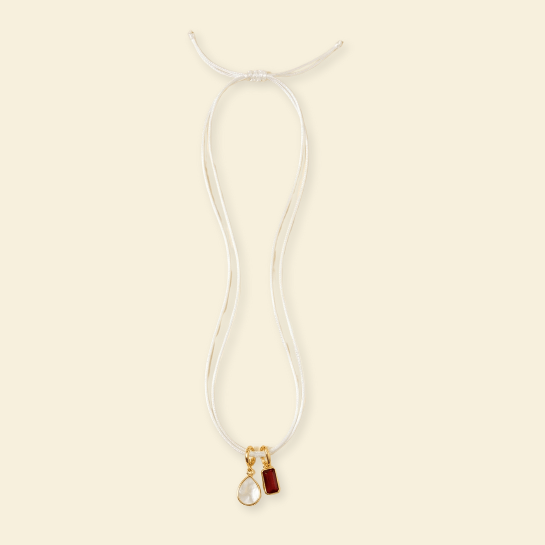 Necklace with two pendants on a beige background