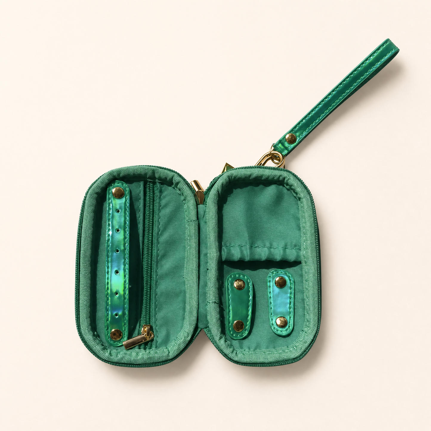 An open green jewelry organizer pouch with a wrist strap, featuring multiple compartments, zipper pockets, and iridescent green accents on a light beige background.