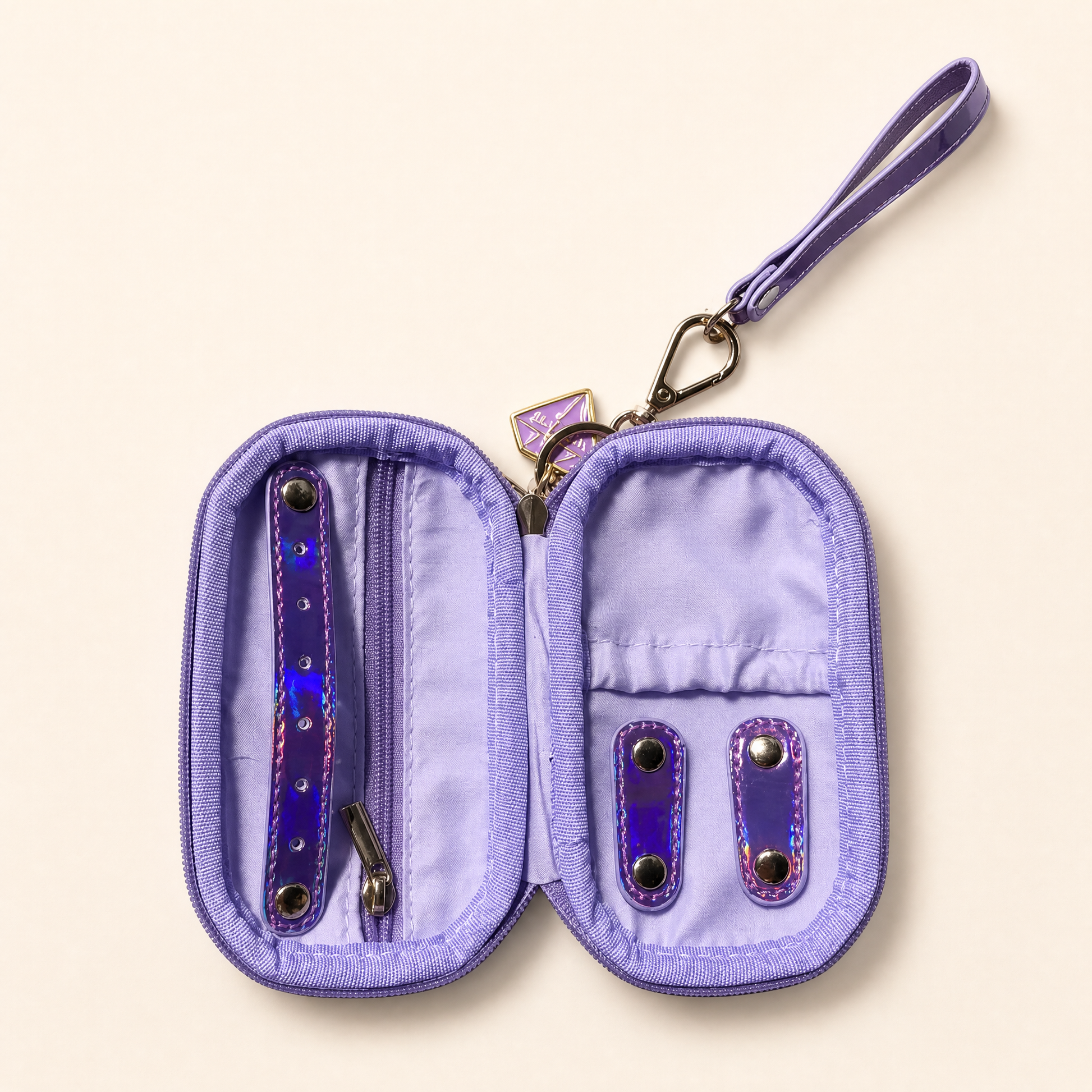 A lavender purple jewelry organizer pouch shown open, featuring a wrist strap, zipper compartment, and two iridescent purple-and-blue barrette holders on a light beige background.