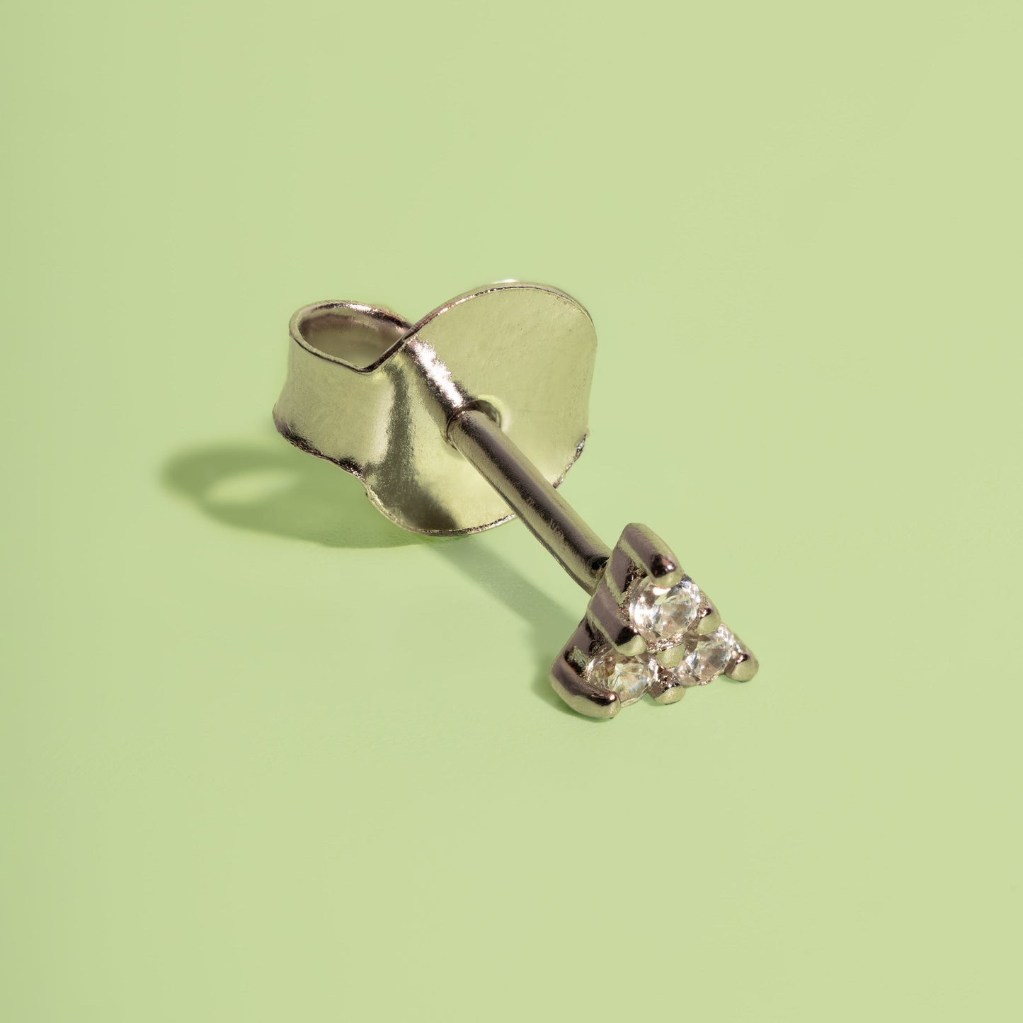 Silver ring with a diamond on a light green background